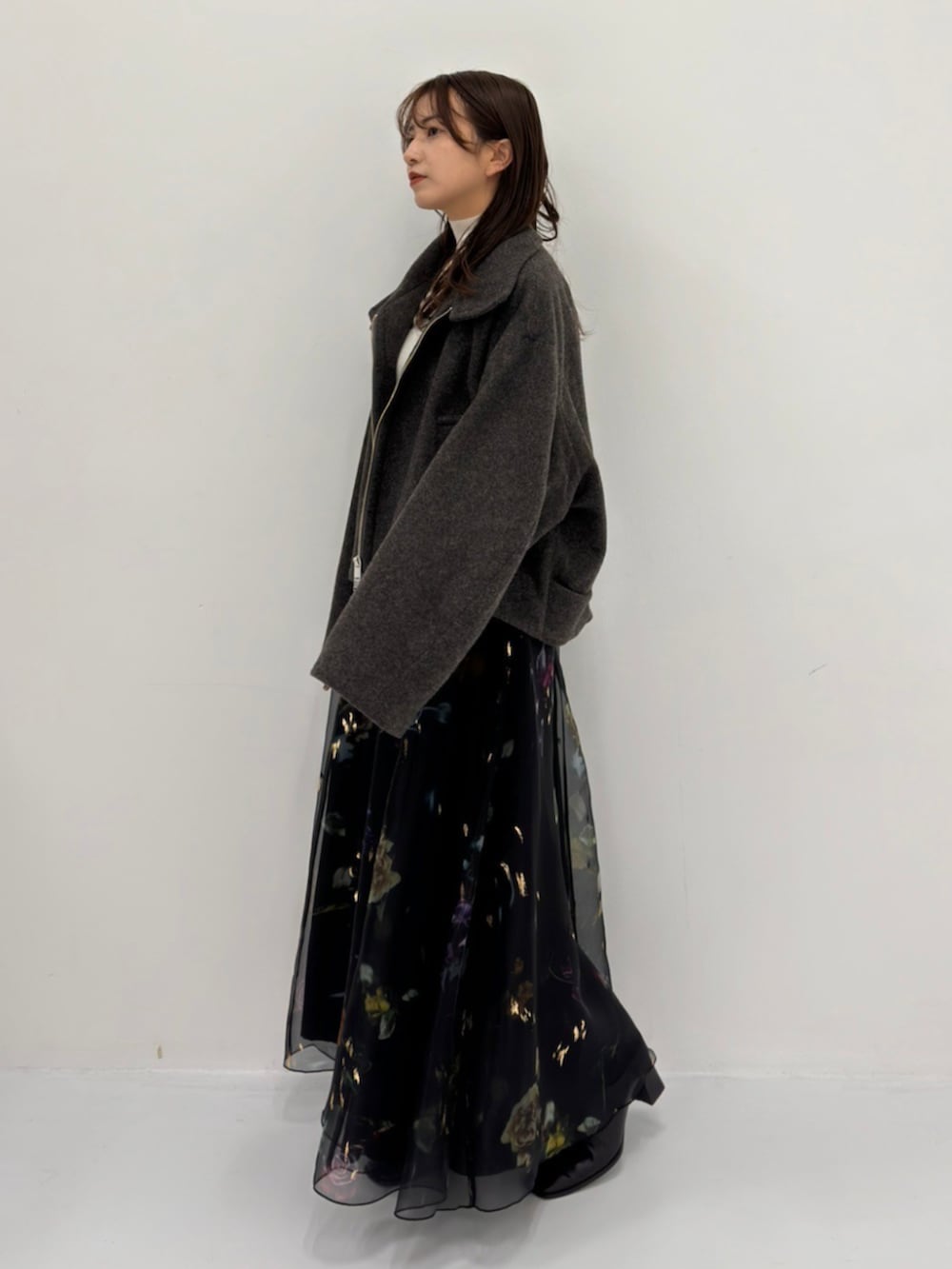 グレー系のブルゾン、ホワイト系のニット/セーターを着用したレディースの秋コーディネートの3枚目の写真