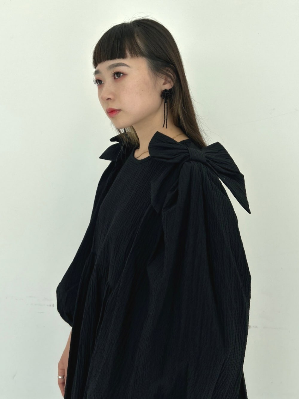 ブラック系のワンピース、ホワイト系のバレエシューズを着用したレディースの秋コーディネートの3枚目の写真