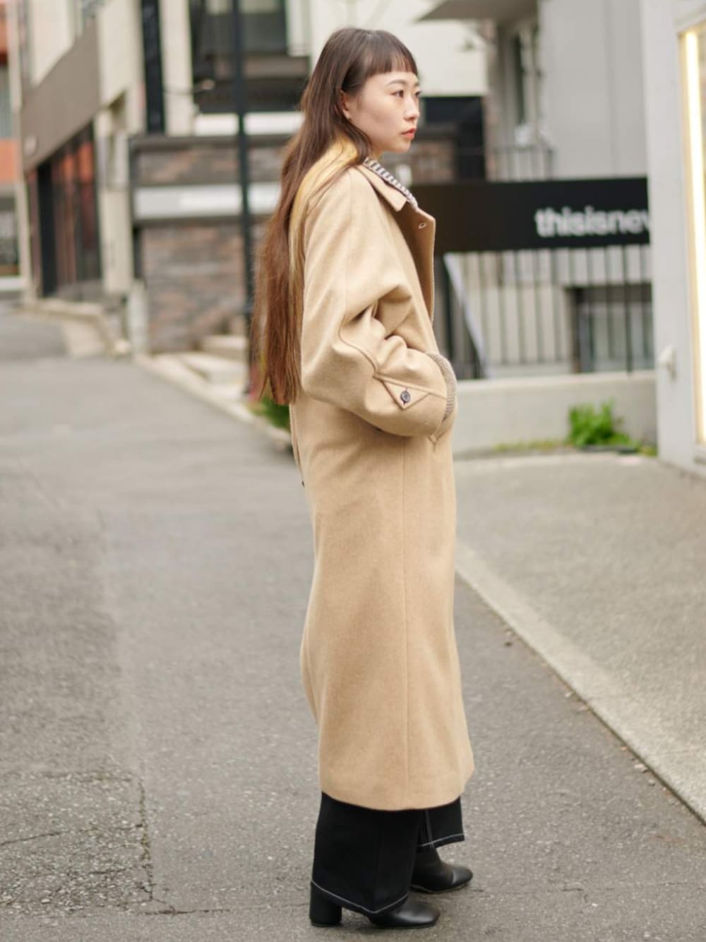 グリーン系のニット/セーター、イエロー系のその他アウターを着用したレディースの冬コーディネートの4枚目の写真