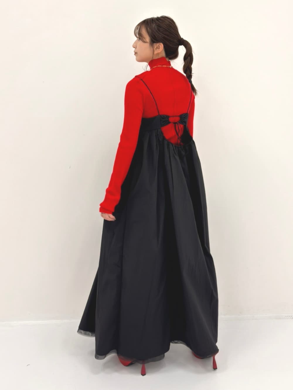 ブラック系のワンピース、レッド系のニット/セーターを着用したレディースの秋コーディネートの3枚目の写真