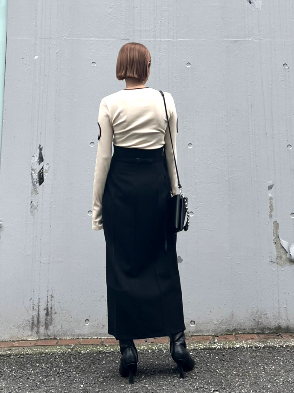 ブラック系のブーツ、ブラック系のスカートを着用したレディースの秋コーディネートの3枚目の写真