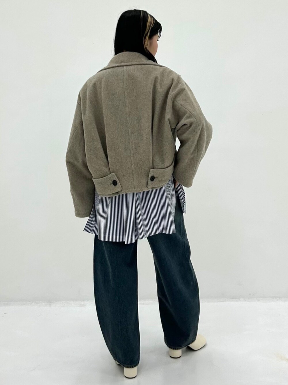 ブルー系のデニムパンツを着用したレディースの秋コーディネートの2枚目の写真