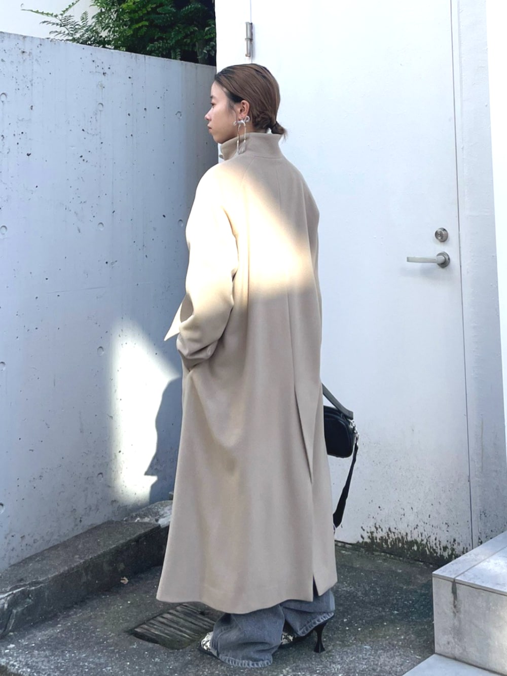 ブラック系のショルダーバッグ、ベージュ系のその他アウターを着用したレディースの秋コーディネートの2枚目の写真