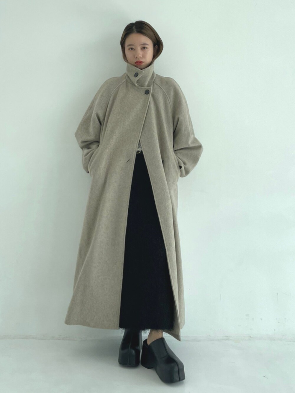 ブラック系のスリッポン、ベージュ系のその他アウターを着用したレディースの秋コーディネートの3枚目の写真