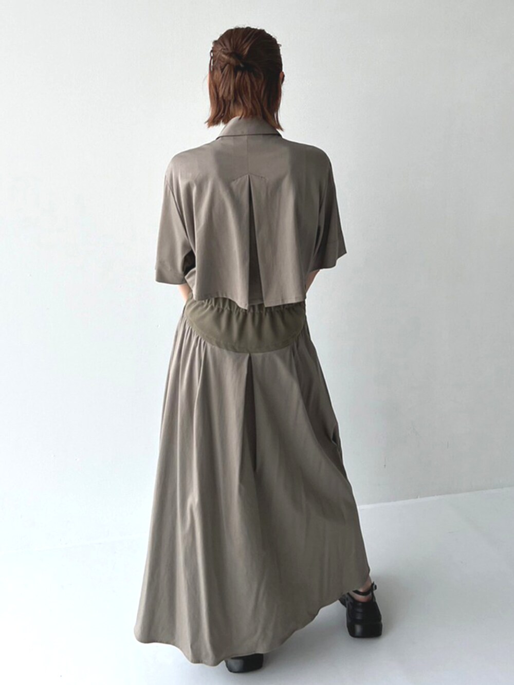 ベージュ系のワンピース、ブラック系のハンドバッグを着用したレディースの冬コーディネートの3枚目の写真