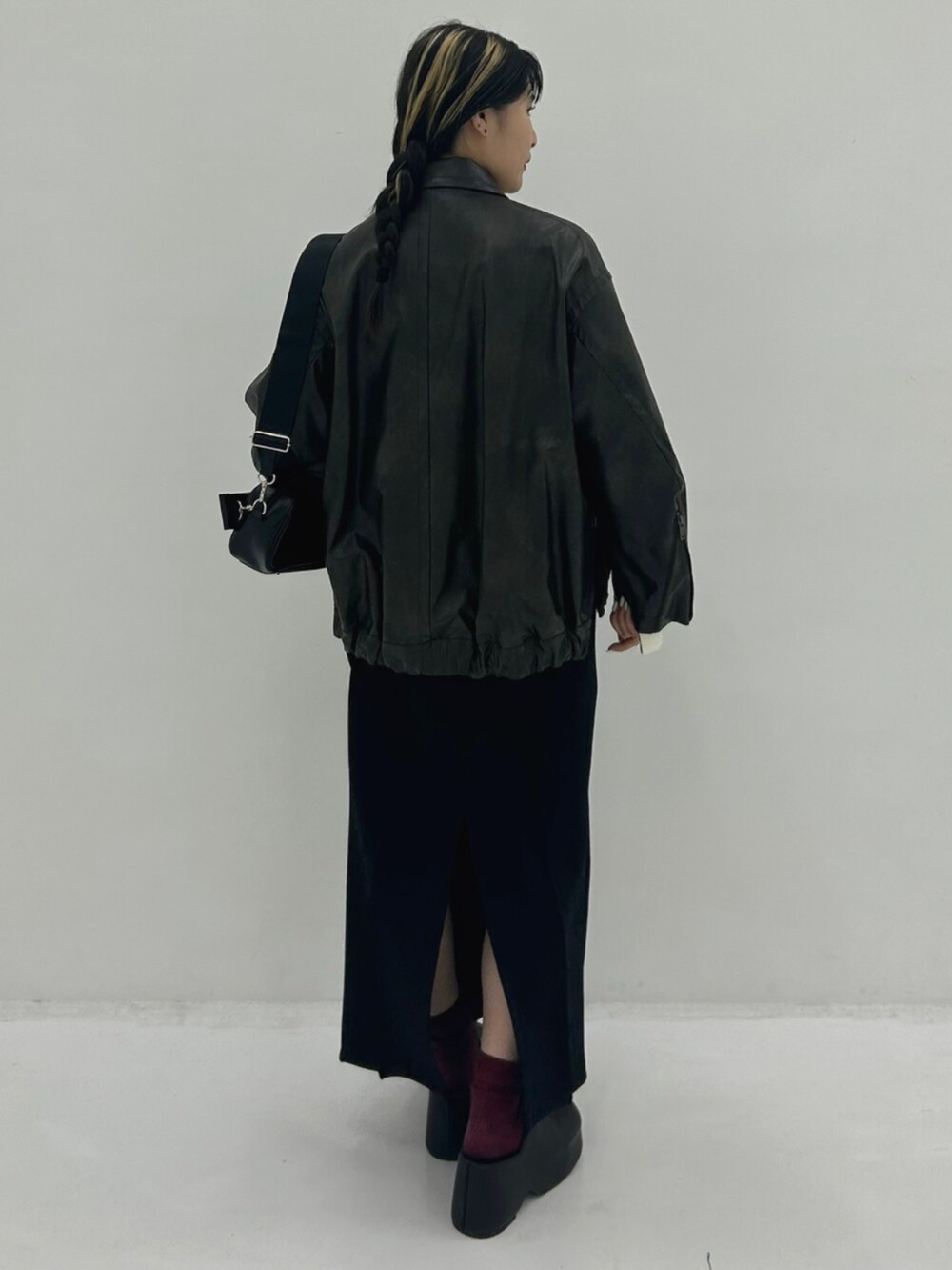 ブラウン系のブルゾン、ブラック系のショルダーバッグを着用したレディースの秋コーディネートの3枚目の写真