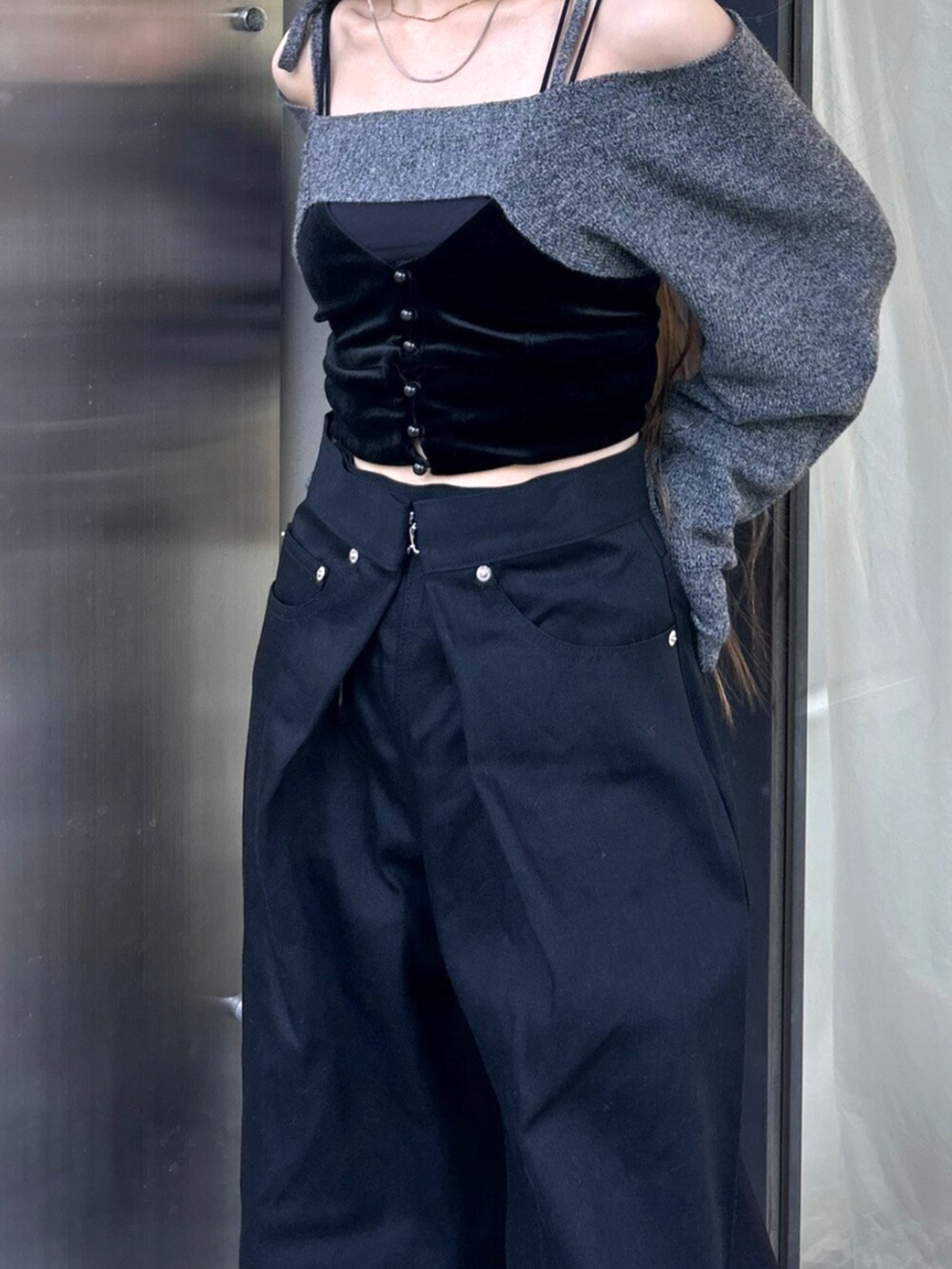 ブラック系のデニムパンツを着用したレディースの秋コーディネートの2枚目の写真