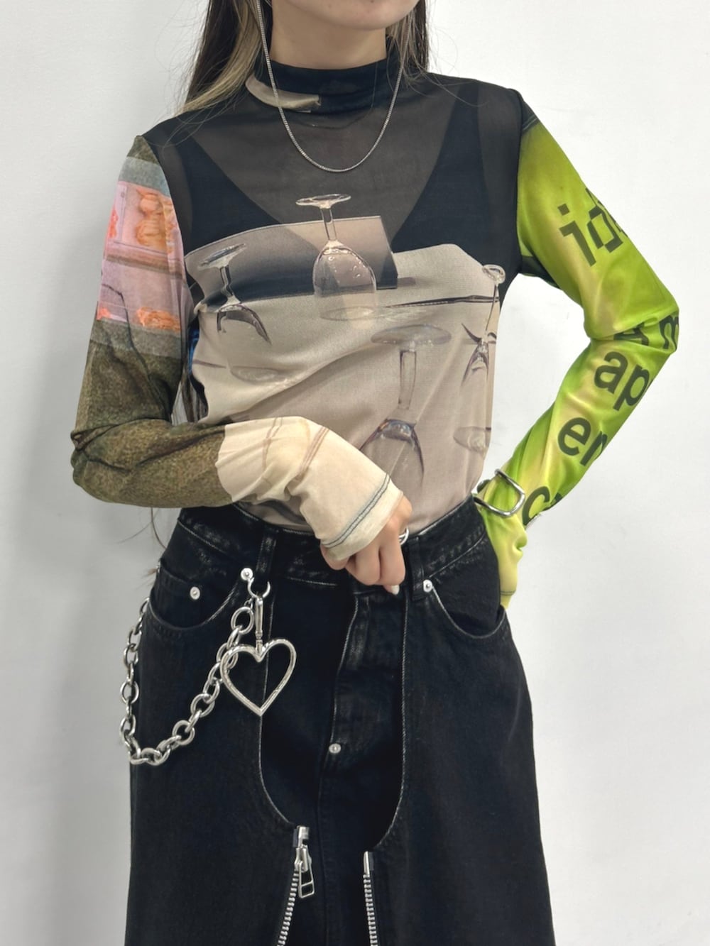 ブラック系のTシャツ/カットソー、ブラック系のデニムスカート、ブラック系のブーツを着用したレディースの秋コーディネートの2枚目の写真