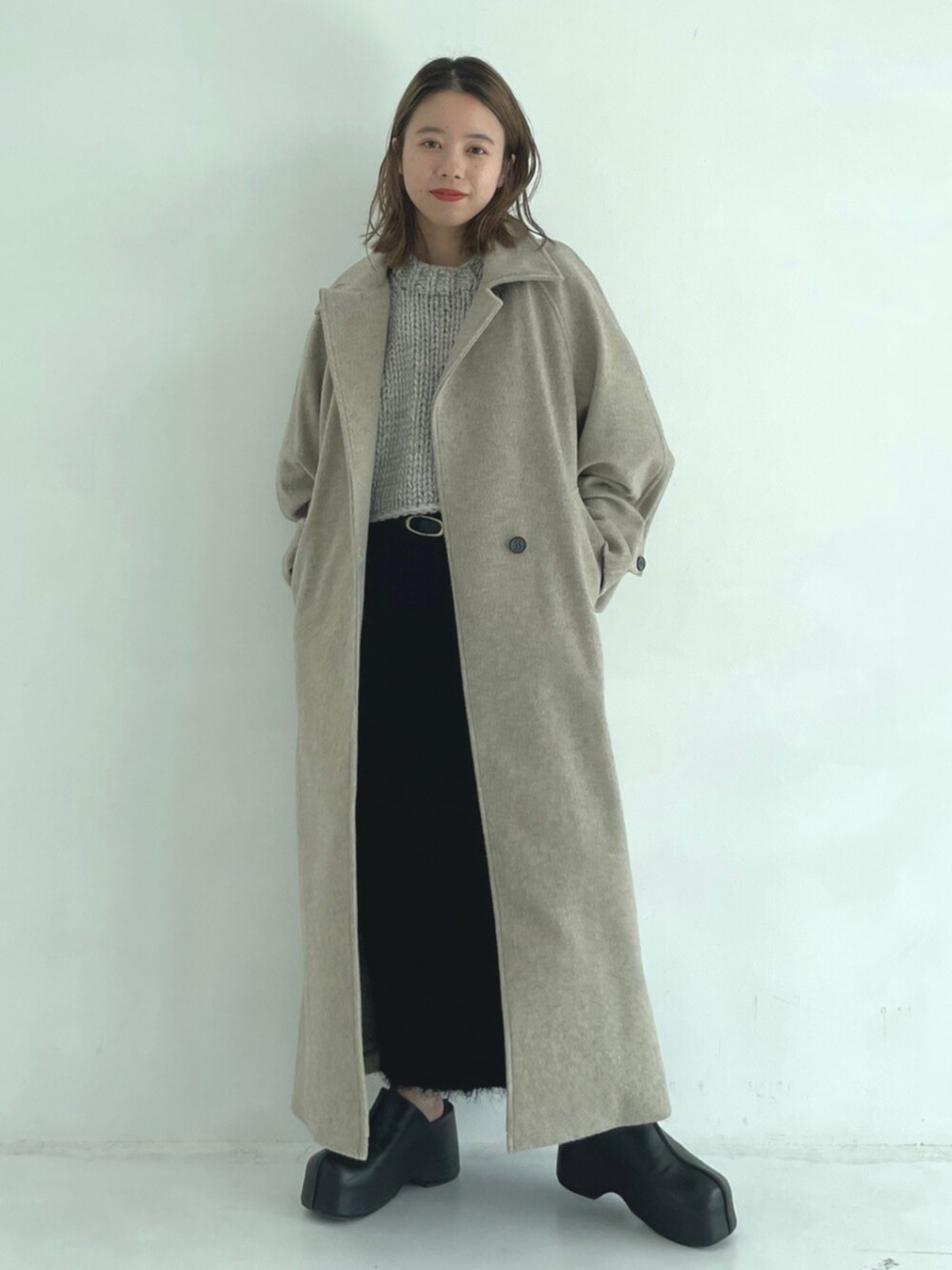 ブラック系のスリッポン、ベージュ系のその他アウターを着用したレディースの秋コーディネートの2枚目の写真