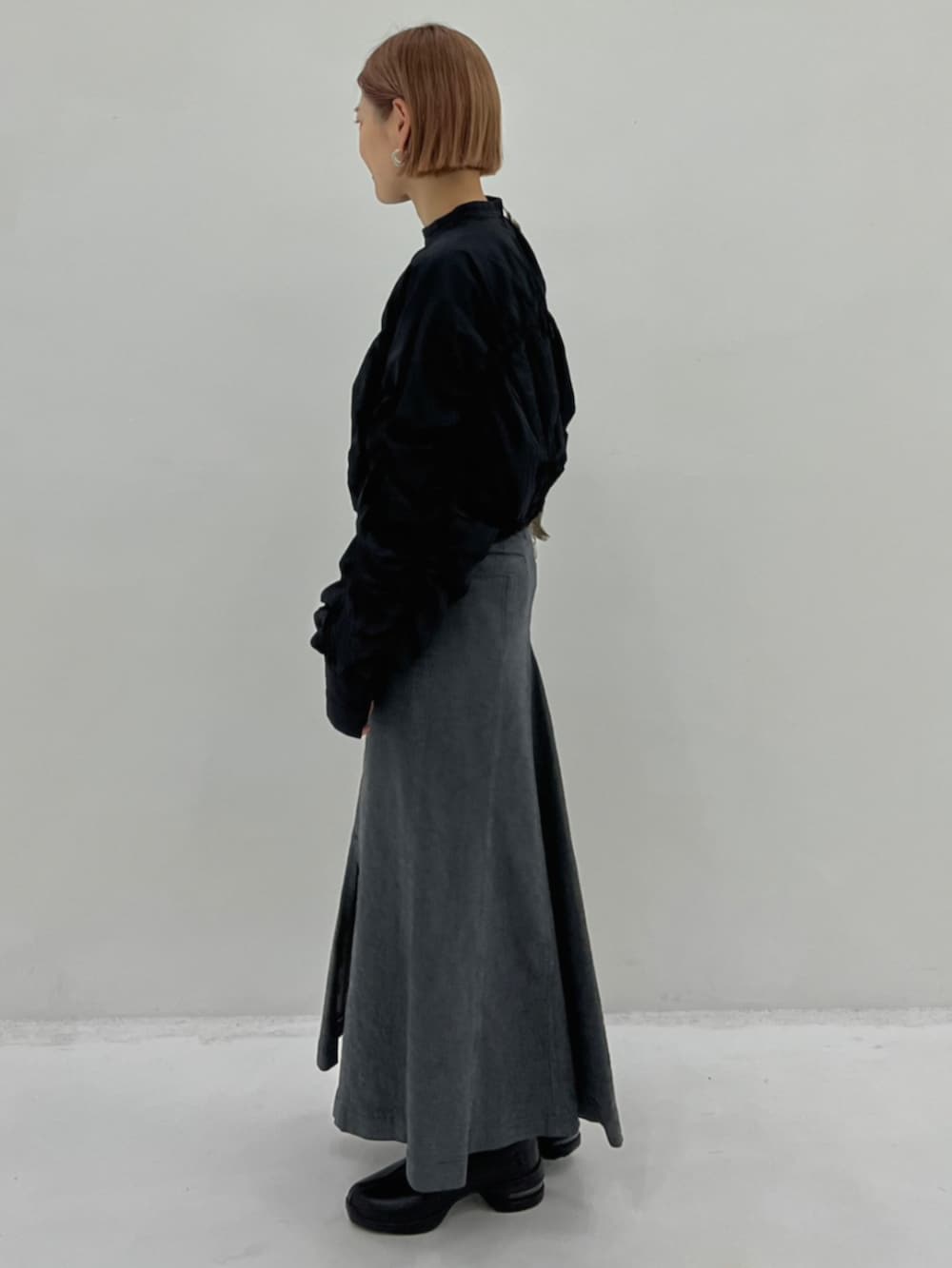 ベージュ系のショルダーバッグ、ブラック系のシャツ/ブラウス、グレー系のスカートを着用したレディースの秋コーディネートの2枚目の写真