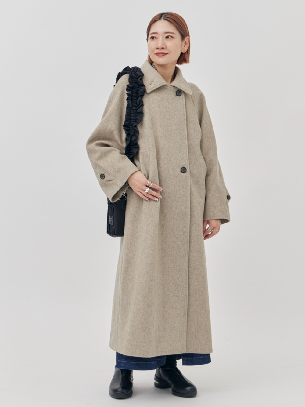 ブラック系のショルダーバッグ、ベージュ系のその他アウターを着用したレディースの秋コーディネートの2枚目の写真