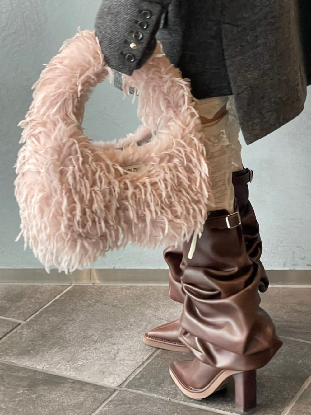 グレー系のテーラードジャケット、ブラウン系のブーツ、ピンク系のショルダーバッグを着用したレディースの秋コーディネートの5枚目の写真