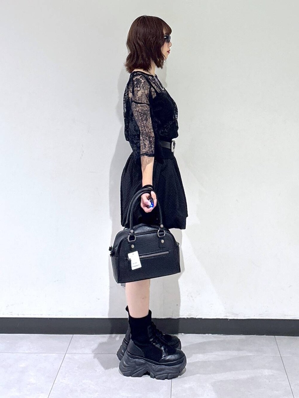 ブラック系のブーツ、ブラック系のTシャツ/カットソー、ブラック系のショルダーバッグを着用したレディースの夏コーディネートの5枚目の写真