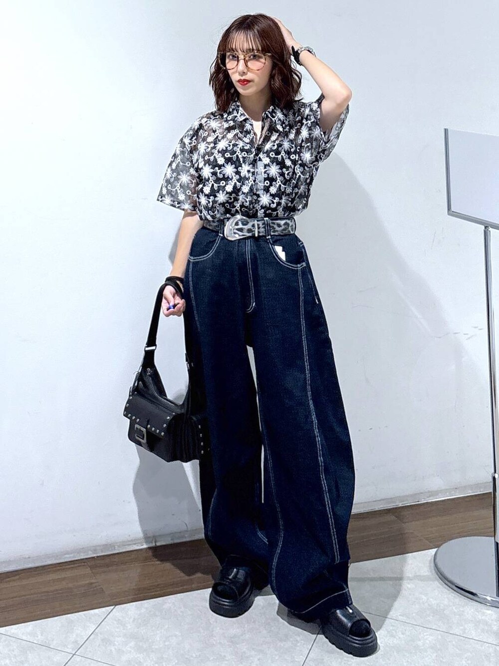 ブラック系のサンダル、ブルー系のデニムパンツ、ブラック系のシャツ/ブラウスを着用したレディースの夏コーディネートの3枚目の写真
