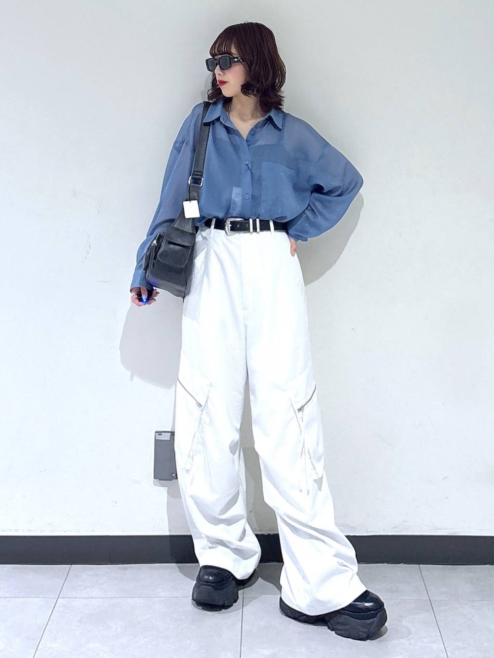 ブラック系のブーツ、ホワイト系のカーゴパンツ、ブルー系のシャツ/ブラウスを着用したレディースの夏コーディネートの2枚目の写真