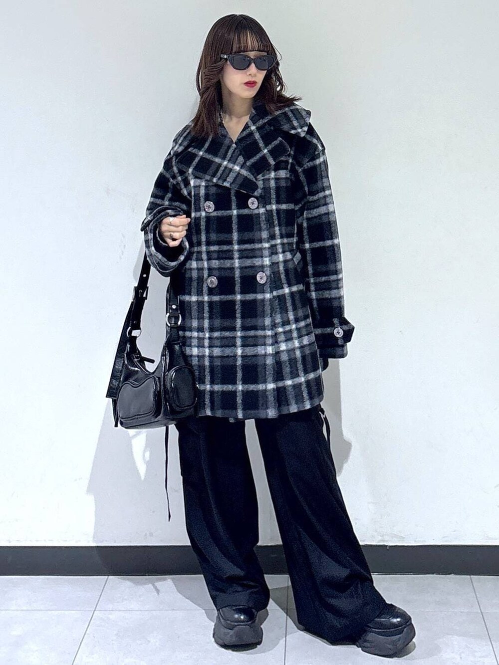 ブラック系のブーツ、ブラック系のチェスターコート、ブラック系のスラックスを着用したレディースの冬コーディネートの4枚目の写真