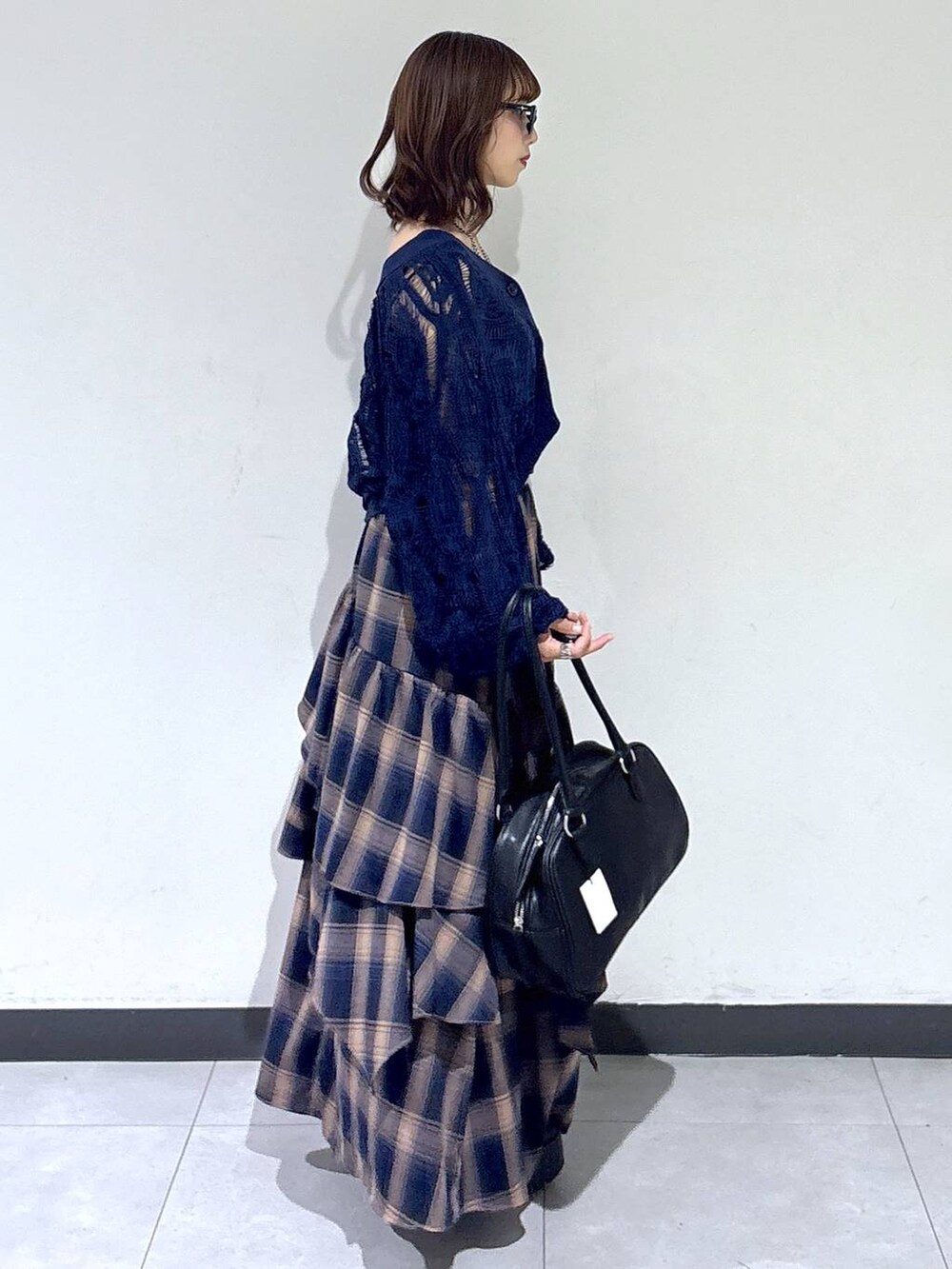 ブルー系のカーディガン/ボレロ、ブラック系のボストンバッグ、ブラウン系のスカートを着用したレディースの秋コーディネートの3枚目の写真