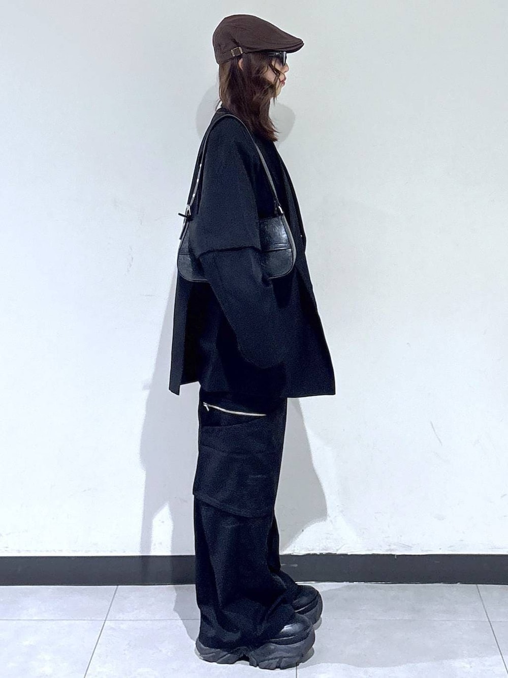 ブラック系のブーツ、ブラック系のハンドバッグ、グレー系のスウェットを着用したレディースの春コーディネートの3枚目の写真