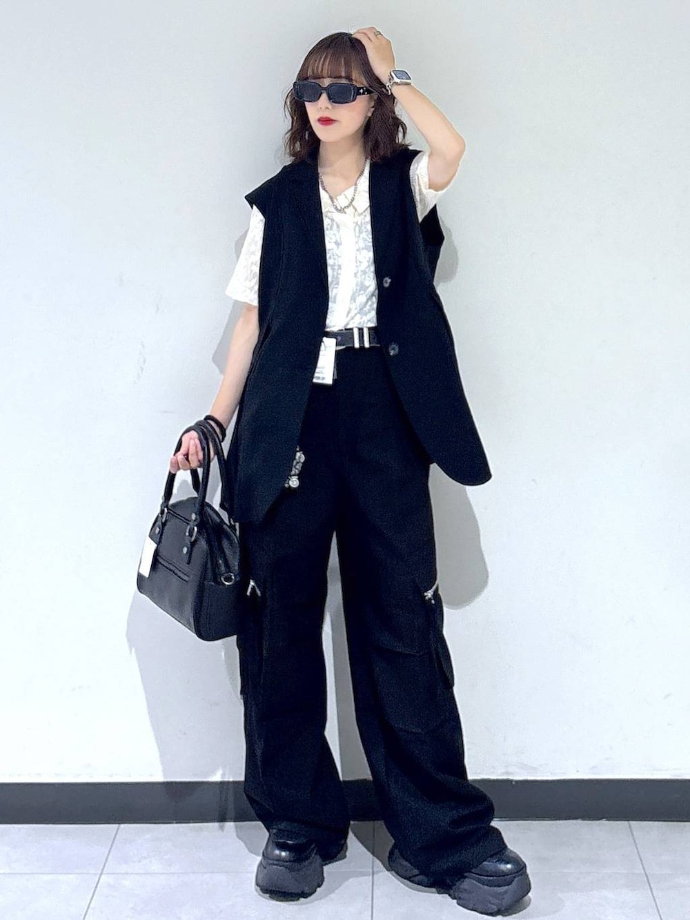 ブラック系のブーツ、ブラック系のカーゴパンツ、ブラック系のベストを着用したレディースの夏コーディネートの6枚目の写真