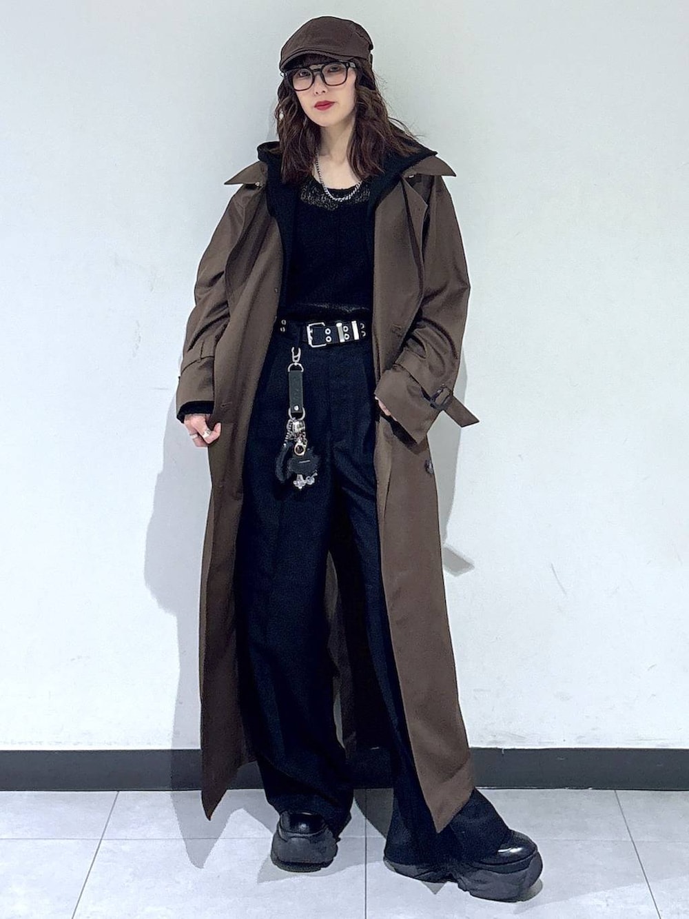 ブラック系のブーツ、ブラウン系のトレンチコート、ブラック系のスラックスを着用したレディースの春コーディネートの2枚目の写真