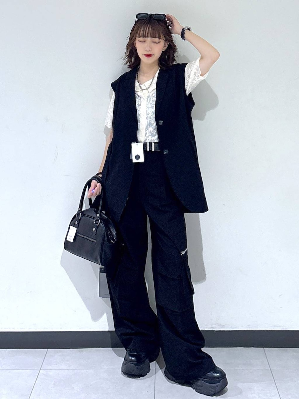 ブラック系のブーツ、ブラック系のカーゴパンツ、ブラック系のベストを着用したレディースの夏コーディネートの3枚目の写真