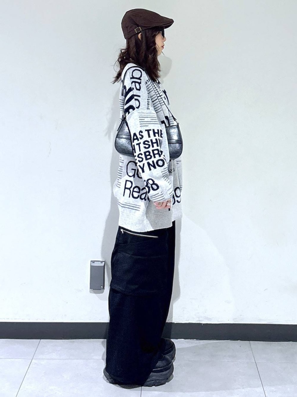 ブラック系のブーツ、ブラック系のハンドバッグ、グレー系のニット/セーターを着用したレディースの春コーディネートの4枚目の写真