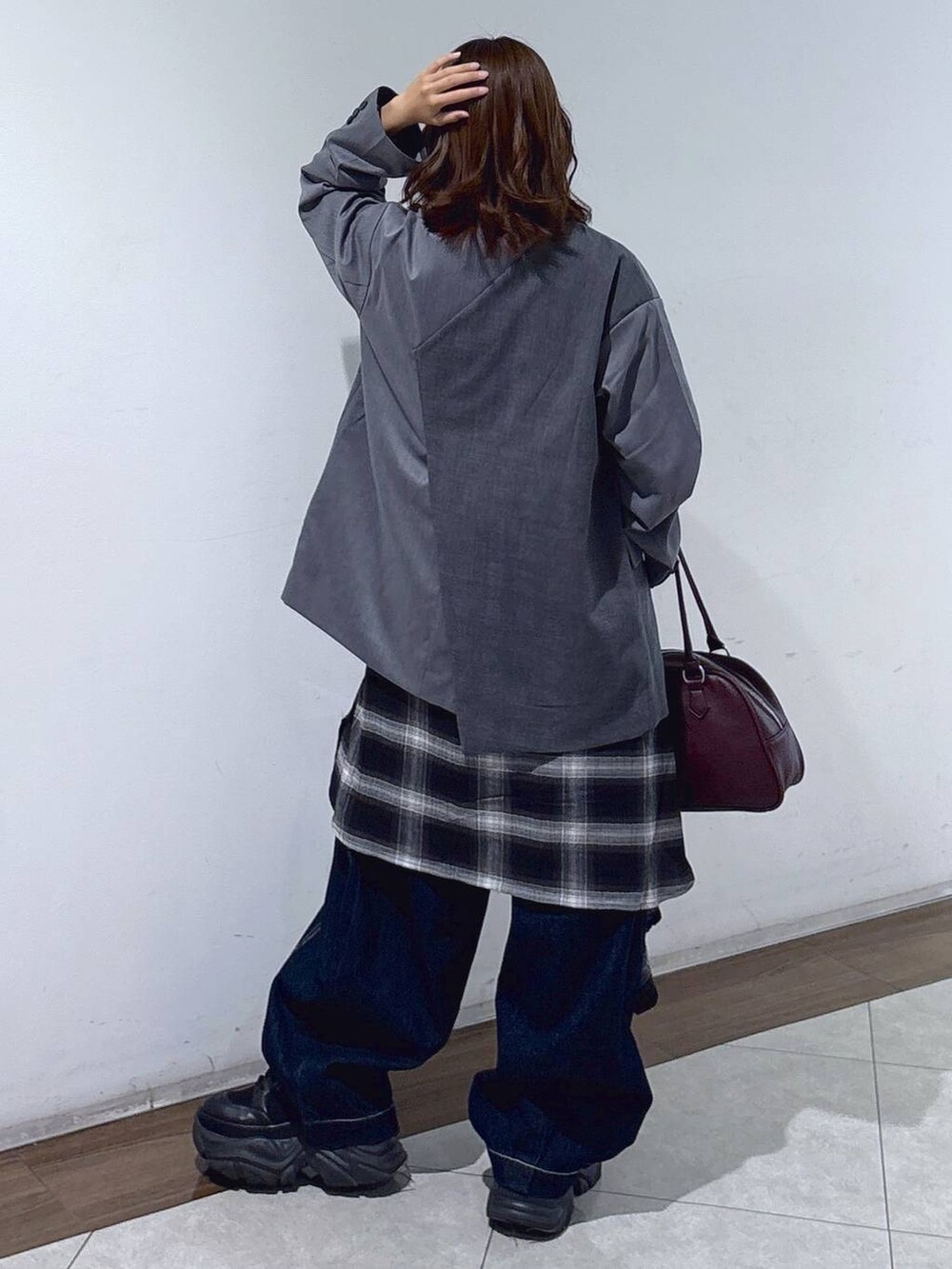 ブラック系のブーツ、ブルー系のデニムパンツ、グレー系のテーラードジャケットを着用したレディースの秋コーディネートの6枚目の写真
