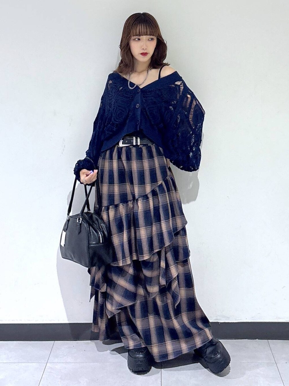 ブルー系のカーディガン/ボレロ、ブラック系のボストンバッグ、ブラウン系のスカートを着用したレディースの秋コーディネートの2枚目の写真