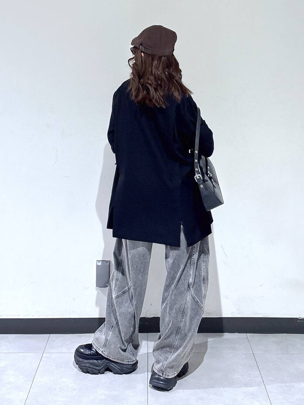 ブラック系のブーツ、ブラック系のハンドバッグ、ブラック系のニット/セーターを着用したレディースの春コーディネートの6枚目の写真