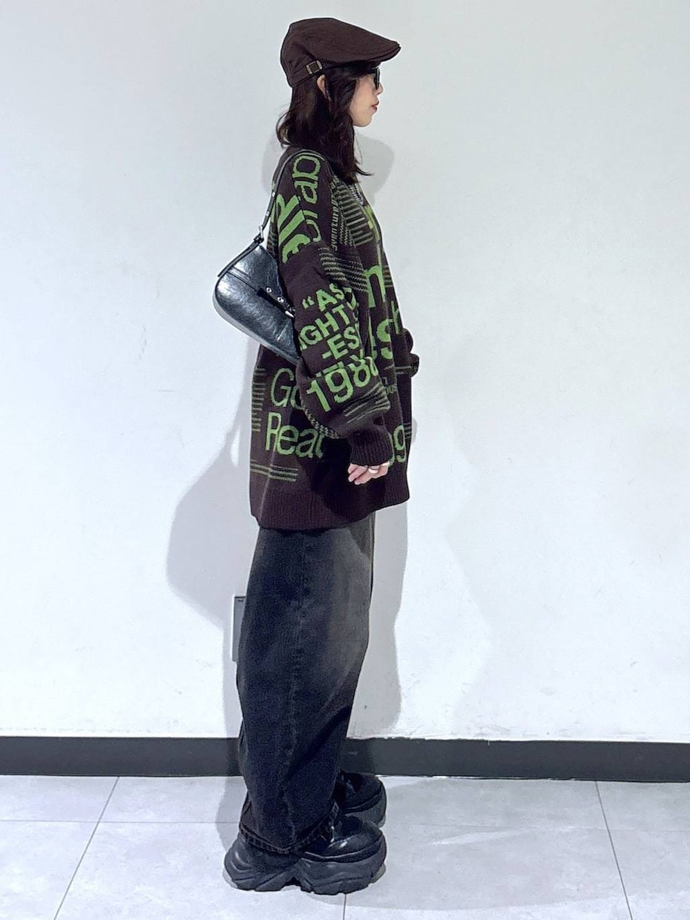 ブラック系のブーツ、ブラック系のデニムパンツ、ブラウン系のニット/セーターを着用したレディースの冬コーディネートの5枚目の写真