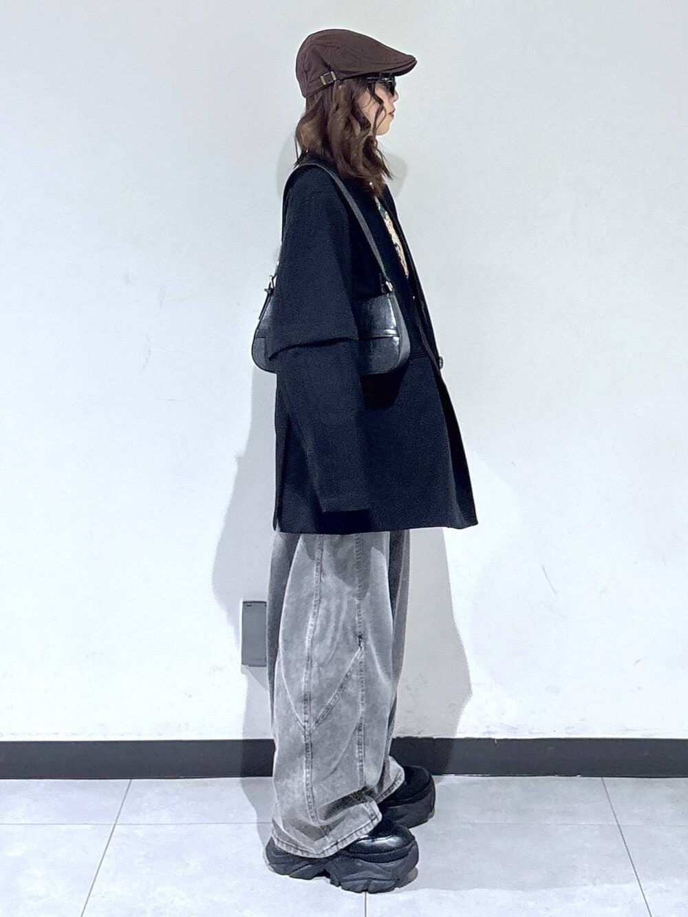 ブラック系のブーツ、ブラック系のハンドバッグ、グレー系のスウェットを着用したレディースの春コーディネートの4枚目の写真