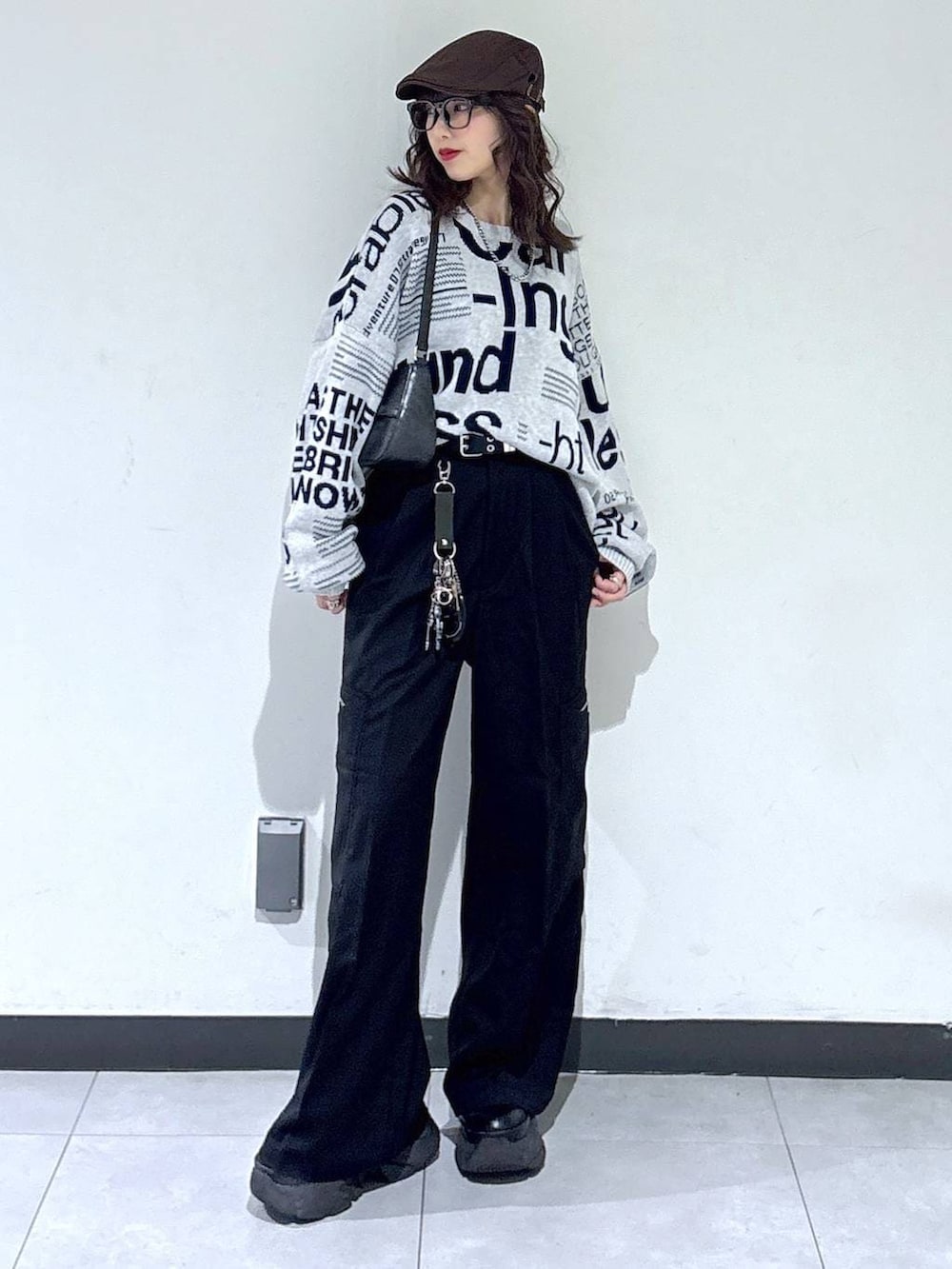 ブラック系のブーツ、ブラック系のハンドバッグ、グレー系のニット/セーターを着用したレディースの春コーディネートの6枚目の写真