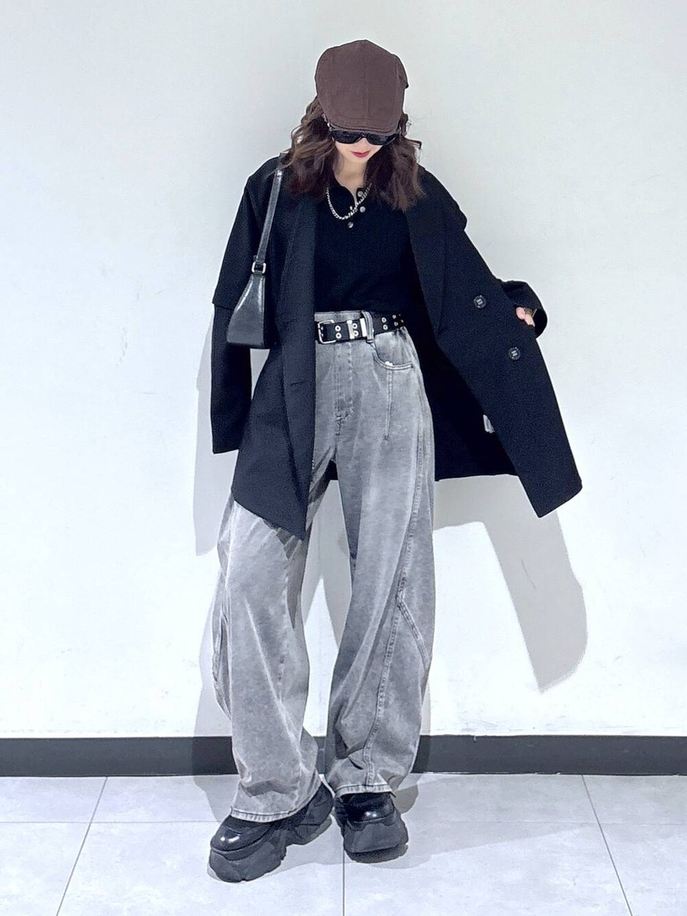 ブラック系のブーツ、ブラック系のハンドバッグ、ブラック系のニット/セーターを着用したレディースの春コーディネートの3枚目の写真