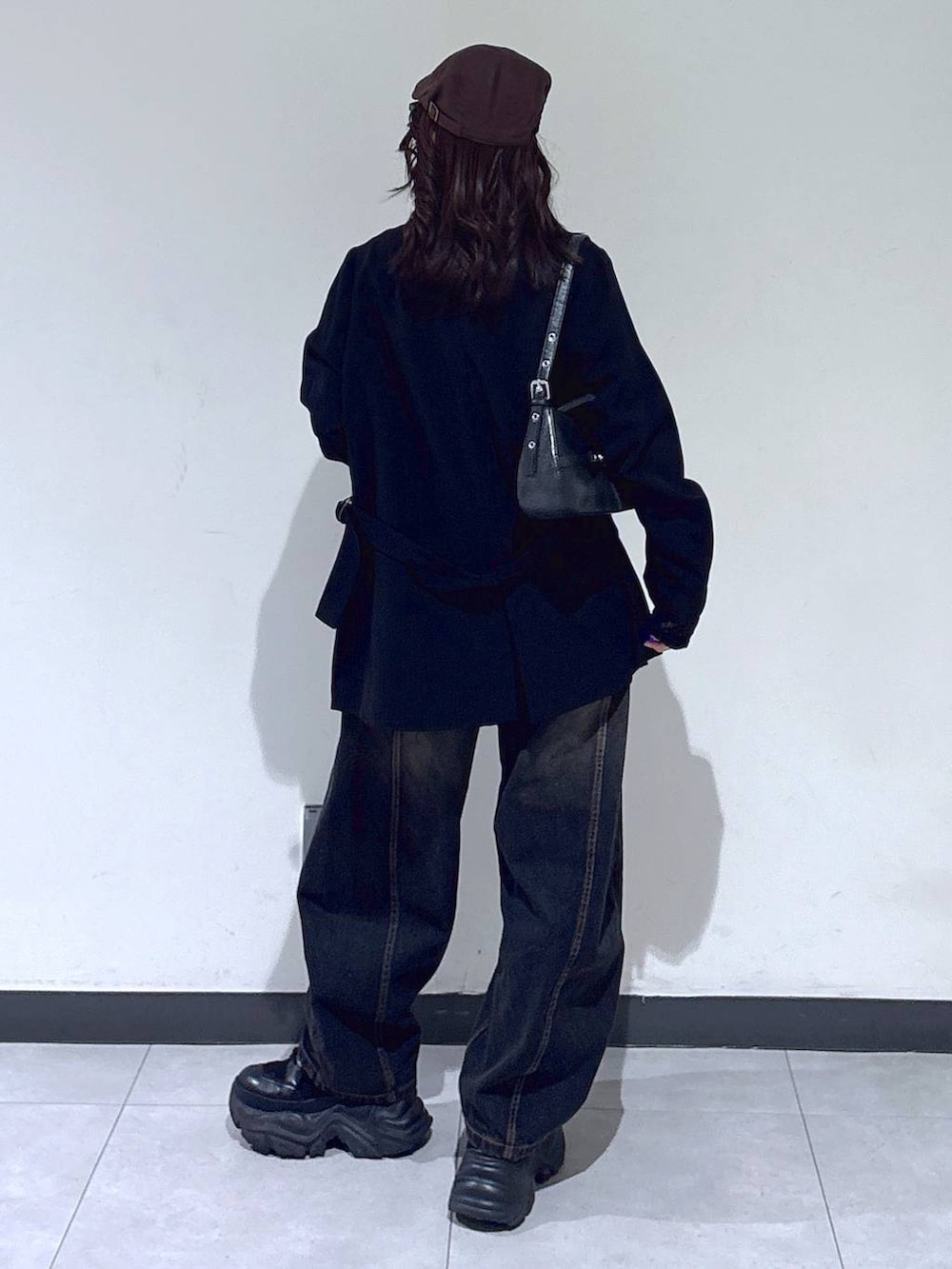 ブラック系のブーツ、ブラック系のTシャツ/カットソー、ブラック系のデニムパンツを着用したレディースの冬コーディネートの7枚目の写真