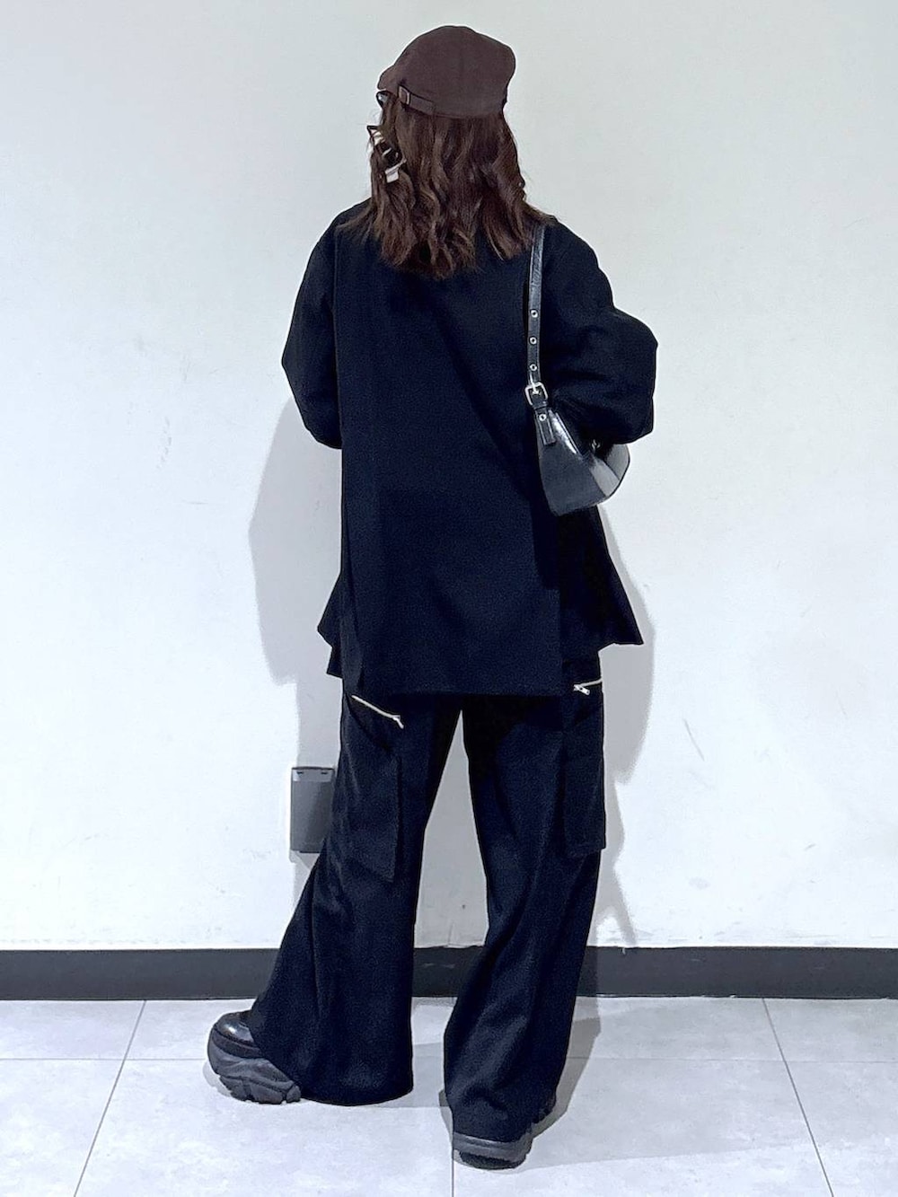 ブラック系のブーツ、ブラック系のハンドバッグ、グレー系のスウェットを着用したレディースの春コーディネートの5枚目の写真