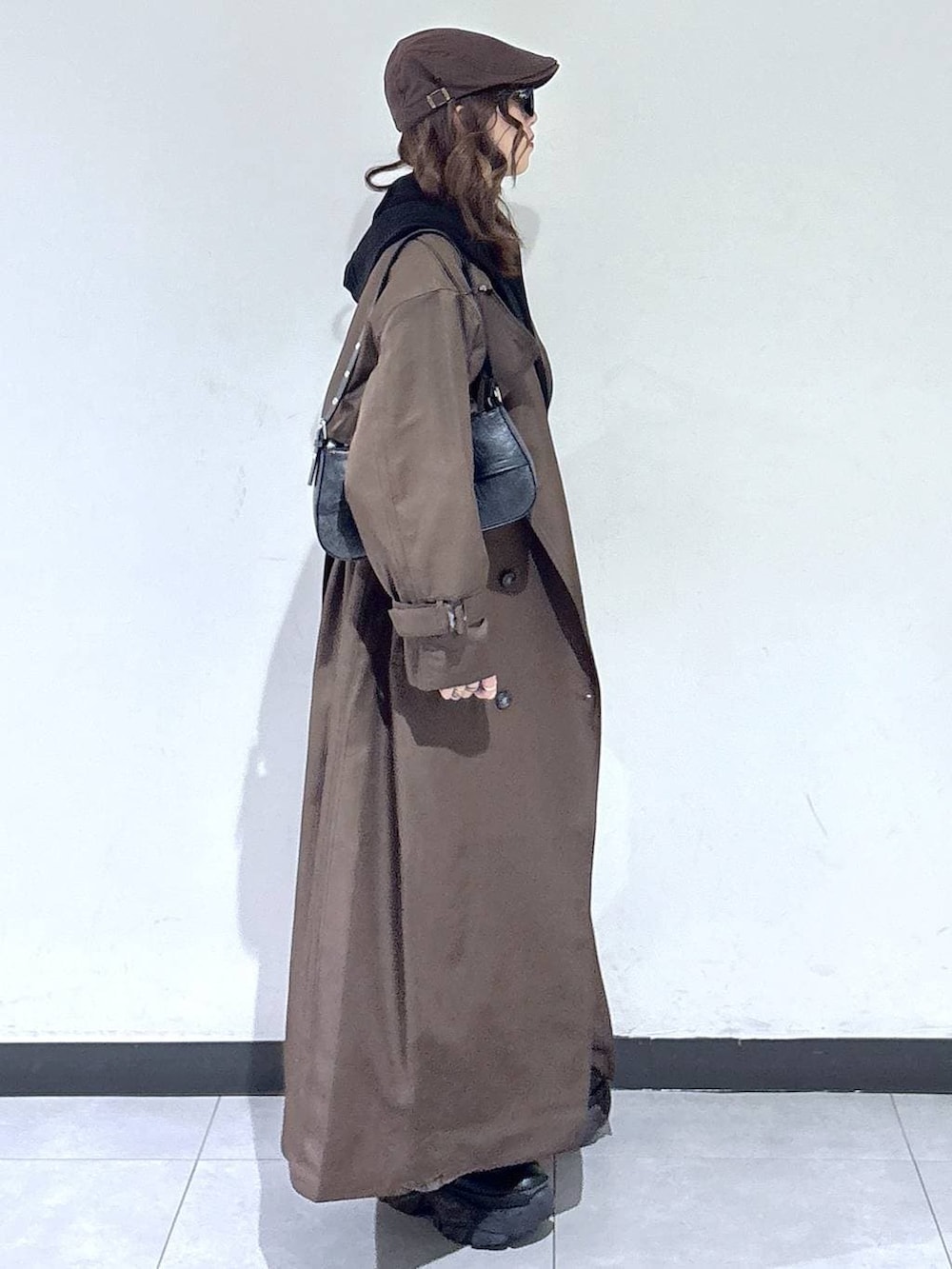 ブラック系のブーツ、ブラウン系のトレンチコート、グレー系のスウェットを着用したレディースの春コーディネートの3枚目の写真