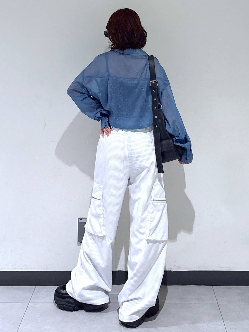 ブラック系のブーツ、ホワイト系のカーゴパンツ、ブルー系のシャツ/ブラウスを着用したレディースの夏コーディネートの6枚目の写真