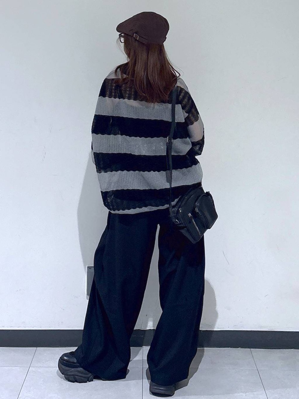 ブラック系のブーツ、ブラック系のスラックス、ブラック系のショルダーバッグを着用したレディースの春コーディネートの7枚目の写真