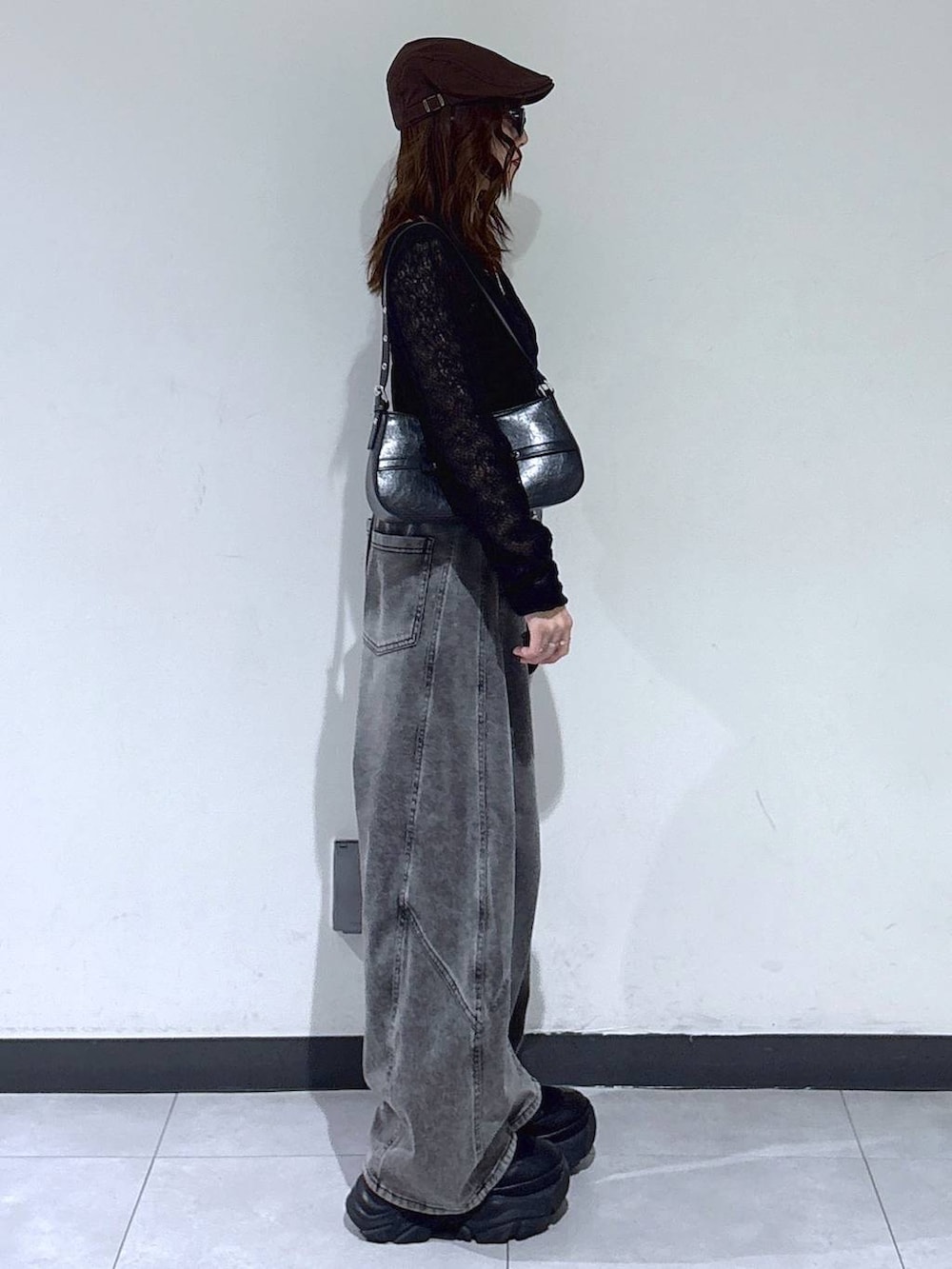 ブラック系のブーツ、ブラック系のハンドバッグ、ブラック系のデニムパンツを着用したレディースの春コーディネートの4枚目の写真