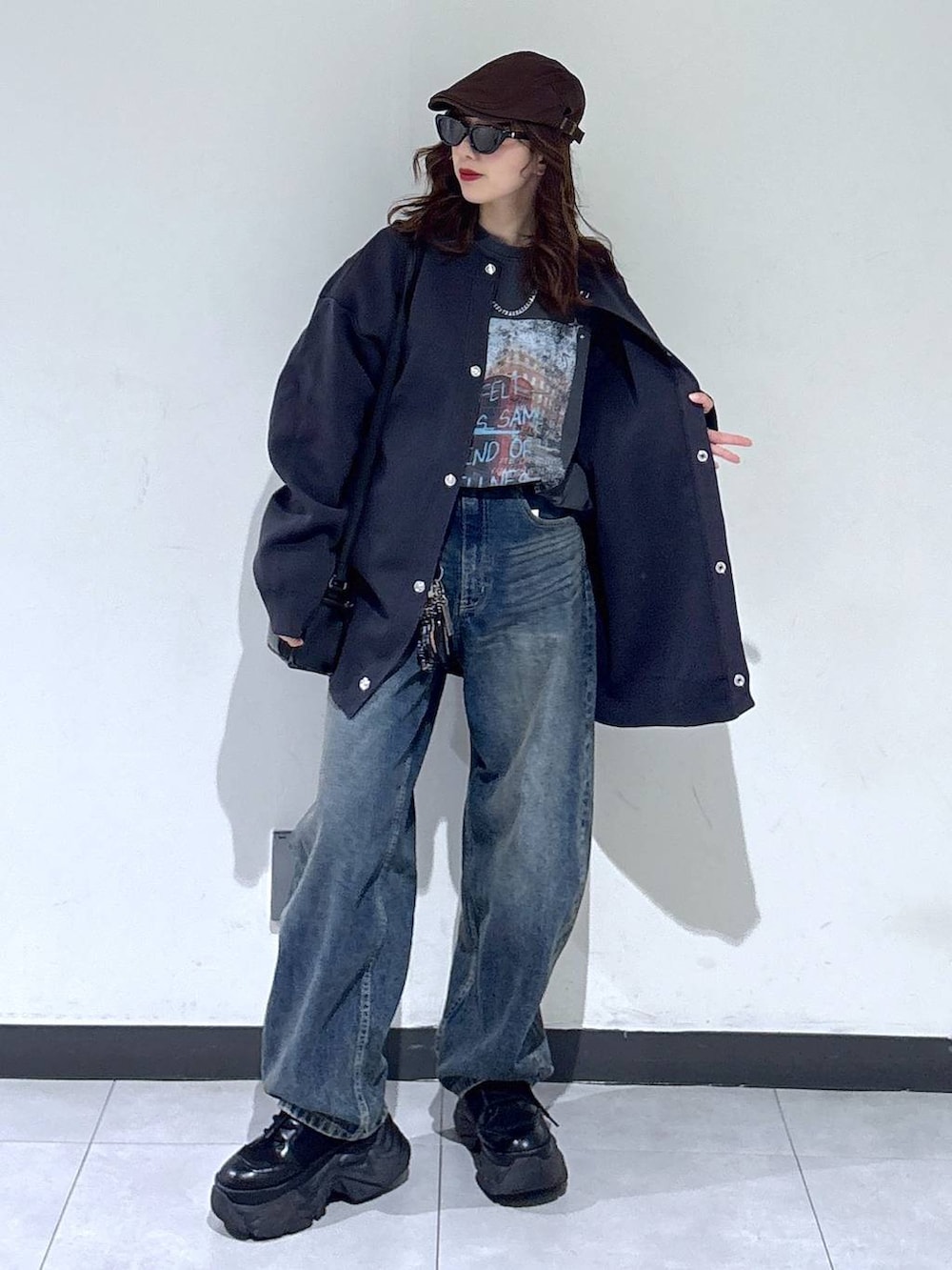 ブラック系のブーツ、ブルー系のデニムパンツ、ブラック系のショルダーバッグを着用したレディースの春コーディネートの2枚目の写真