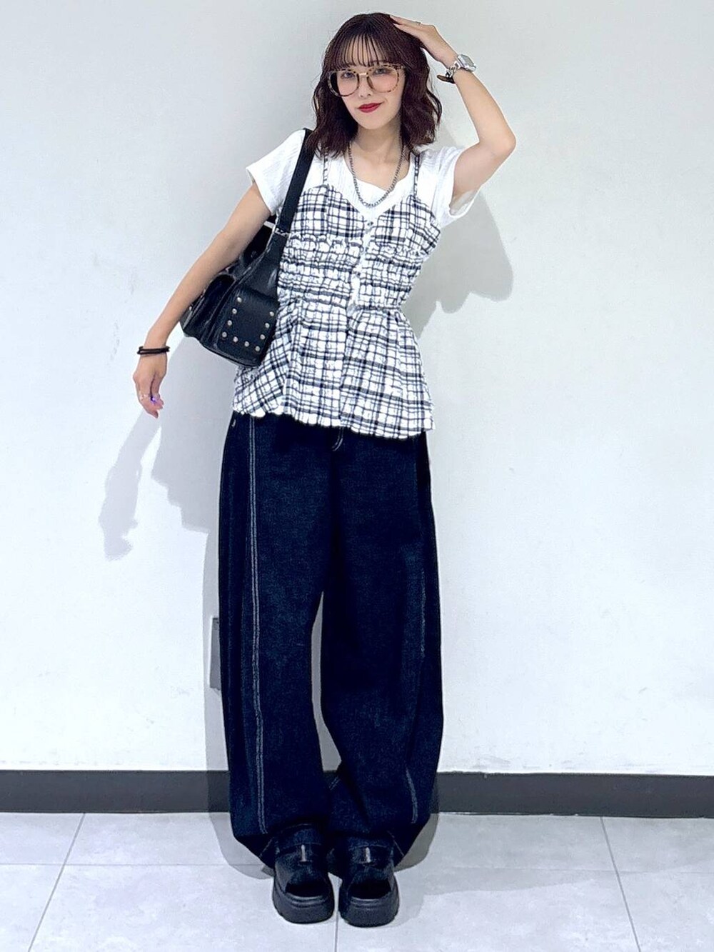 ブラック系のサンダル、ブルー系のデニムパンツ、ブラック系のショルダーバッグを着用したレディースの夏コーディネートの3枚目の写真