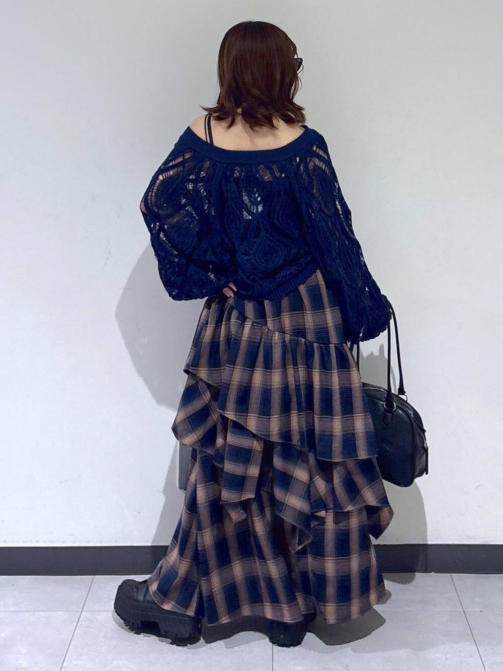 ブルー系のカーディガン/ボレロ、ブラック系のボストンバッグ、ブラウン系のスカートを着用したレディースの秋コーディネートの5枚目の写真