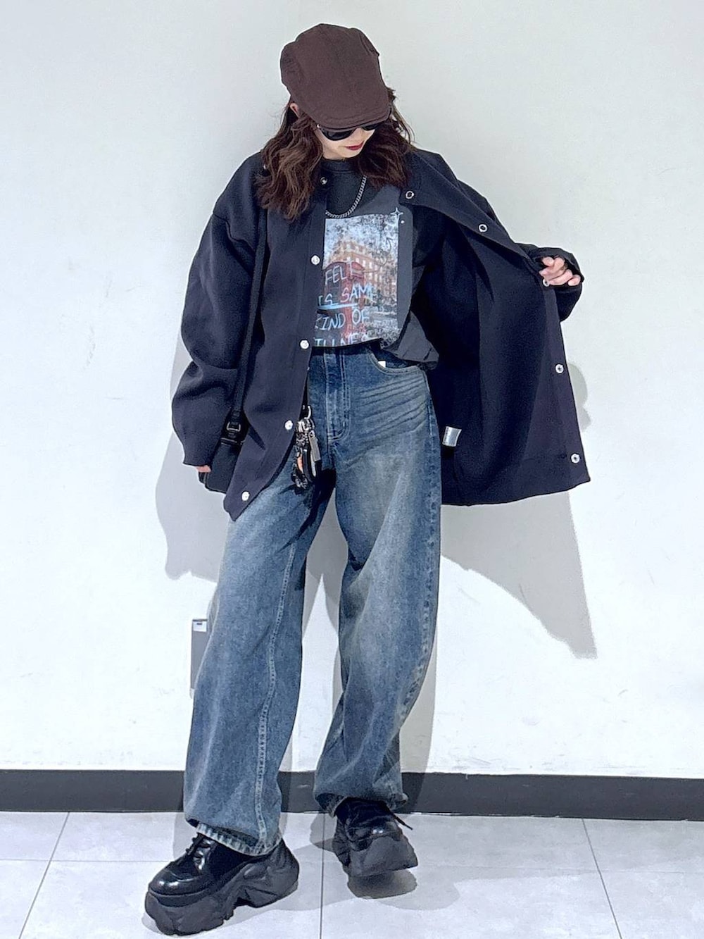 ブラック系のブーツ、ブルー系のデニムパンツ、ブラック系のショルダーバッグを着用したレディースの春コーディネートの5枚目の写真