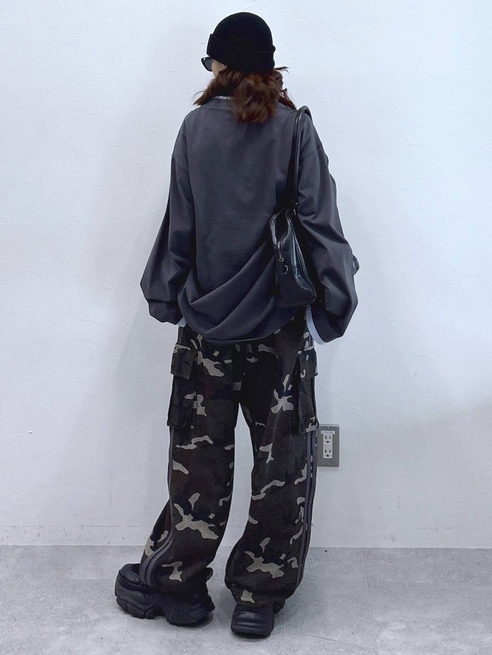 ブラック系のブーツ、ブラック系のボストンバッグ、グレー系のTシャツ/カットソーを着用したレディースの冬コーディネートの7枚目の写真