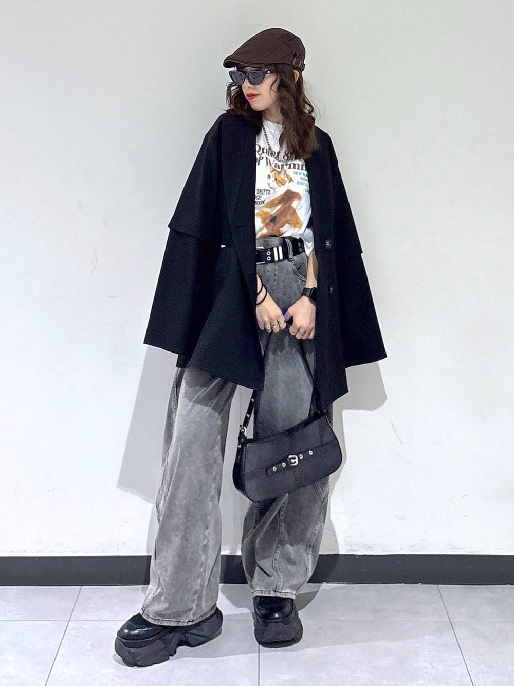 ブラック系のブーツ、ブラック系のハンドバッグ、ブラック系のテーラードジャケットを着用したレディースの春コーディネートの2枚目の写真