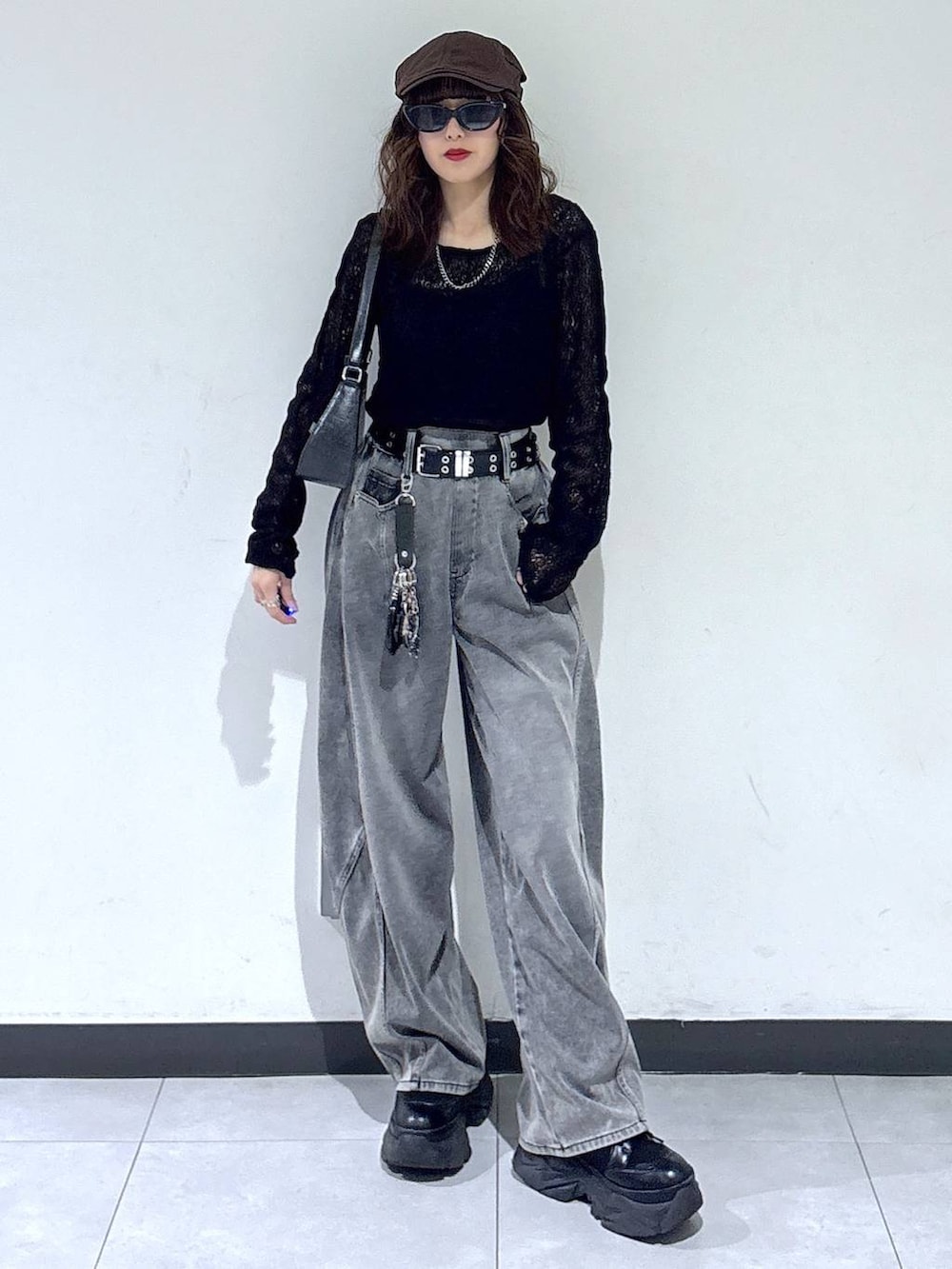 ブラック系のブーツ、ブラック系のハンドバッグ、ブラック系のデニムパンツを着用したレディースの春コーディネートの2枚目の写真