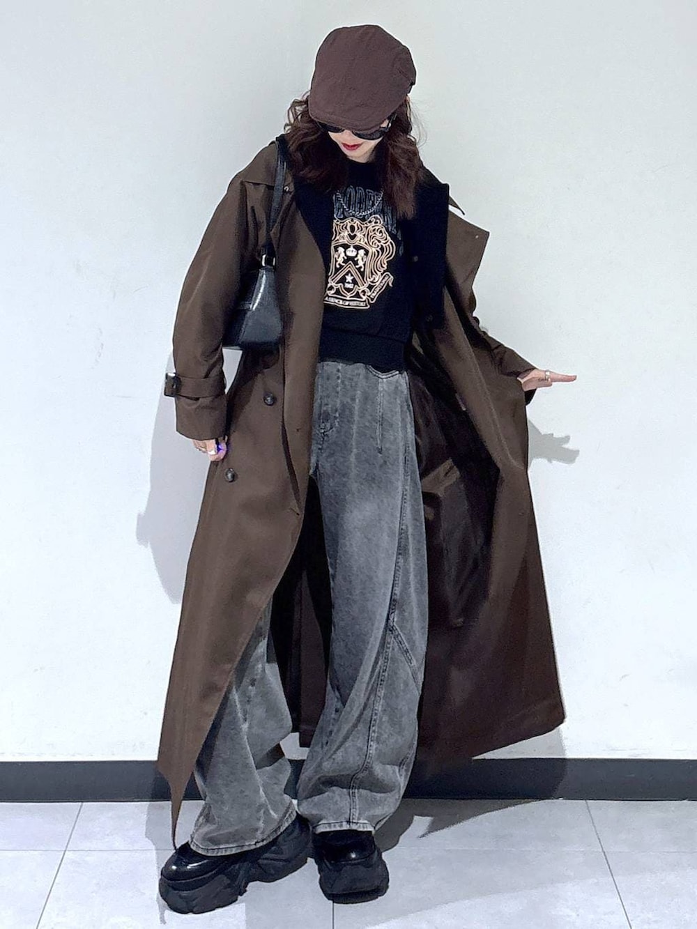 ブラック系のブーツ、ブラウン系のトレンチコート、グレー系のスウェットを着用したレディースの春コーディネートの2枚目の写真