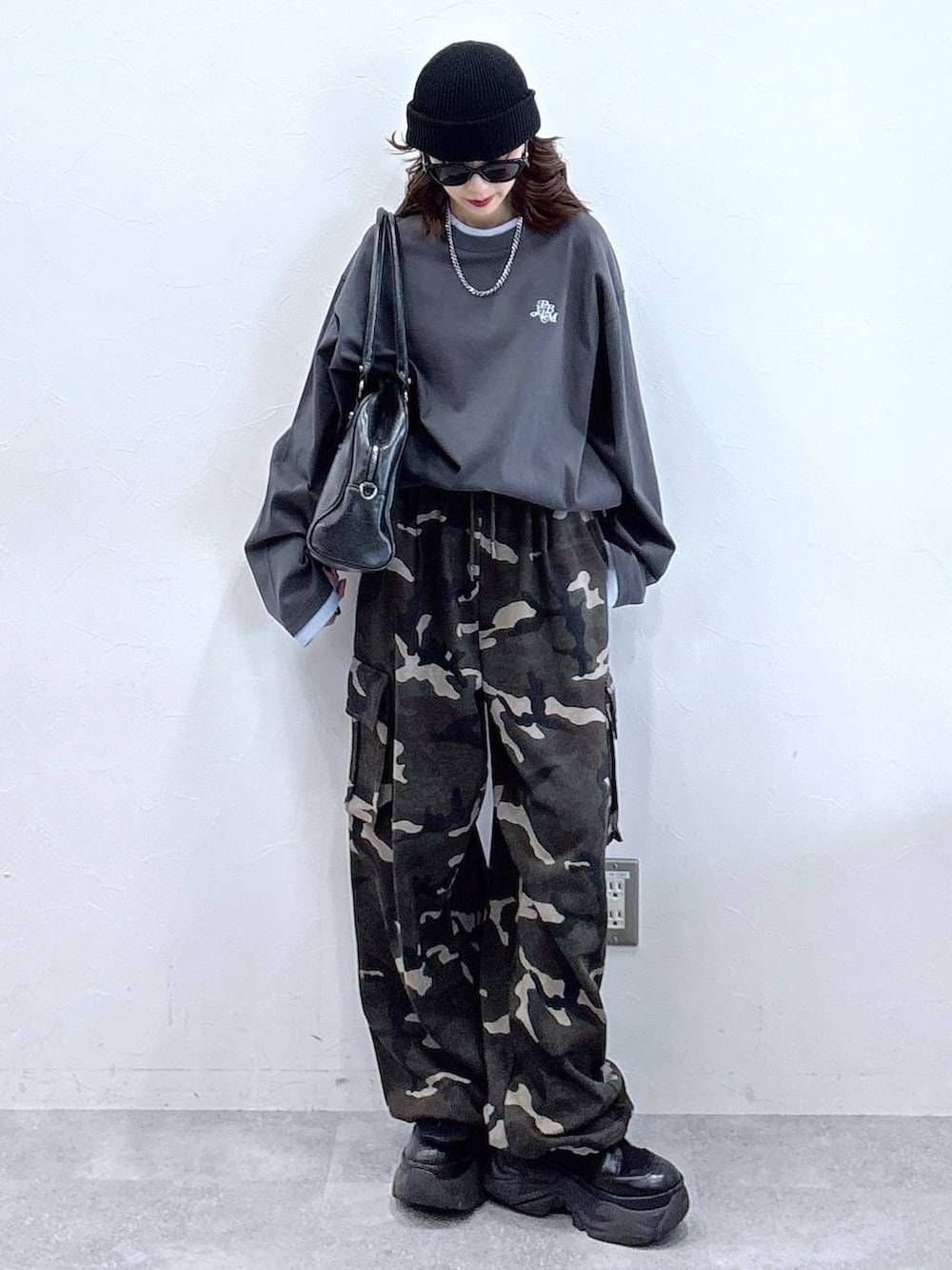 ブラック系のブーツ、ブラック系のボストンバッグ、グレー系のTシャツ/カットソーを着用したレディースの冬コーディネートの3枚目の写真