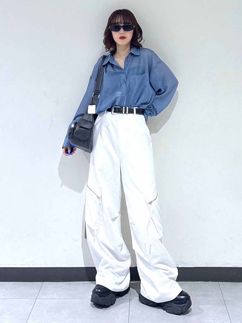 ブラック系のブーツ、ホワイト系のカーゴパンツ、ブルー系のシャツ/ブラウスを着用したレディースの夏コーディネートの5枚目の写真