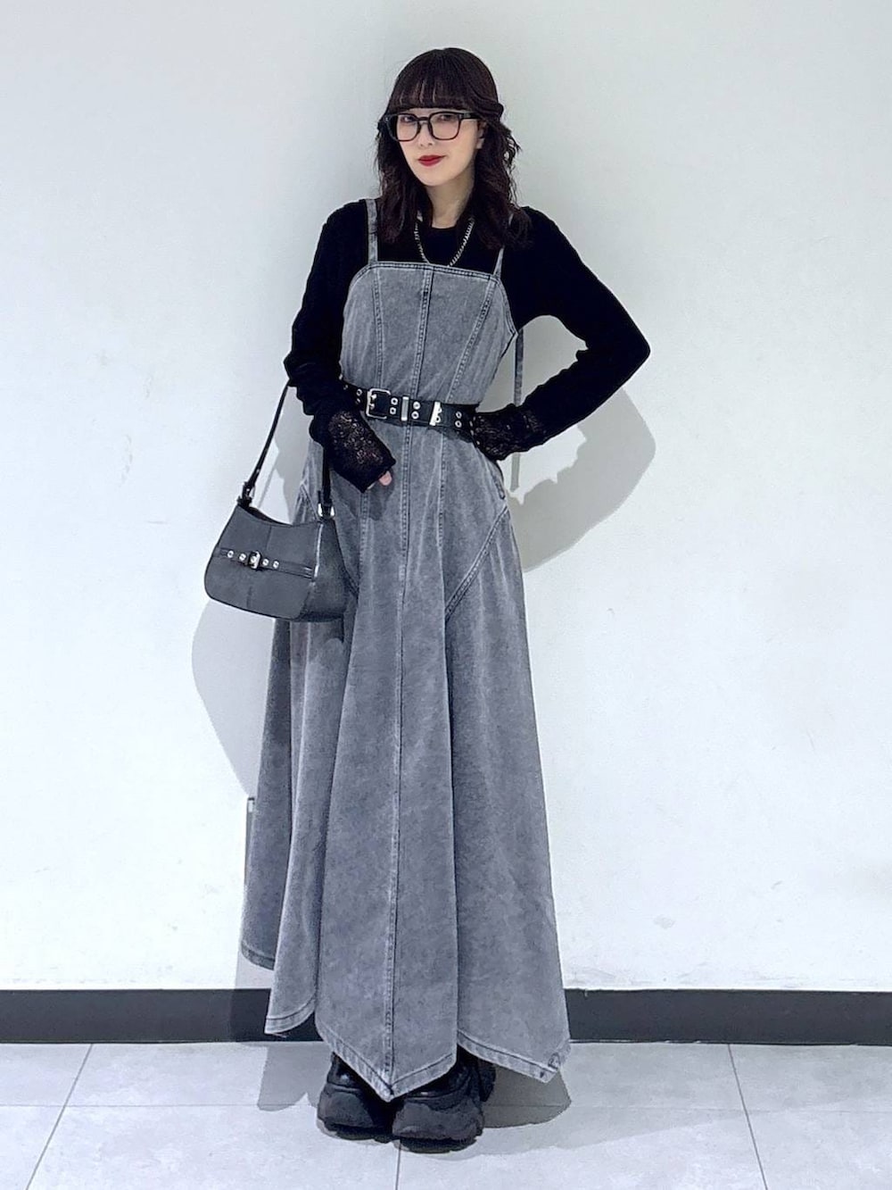 ブラック系のブーツ、ブラック系のTシャツ/カットソー、ブラック系のハンドバッグを着用したレディースの冬コーディネートの6枚目の写真